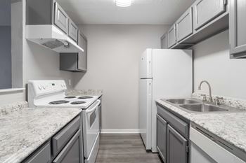 A kitchen with a white stove and a white refrigerator.